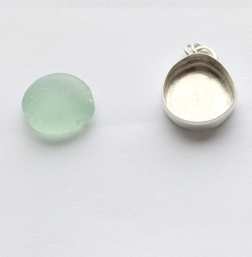 Seafoam sea glass next to silver bezel