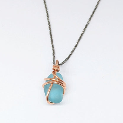 Back view of Turquoise sea glass wrapped in copper pendant on white background