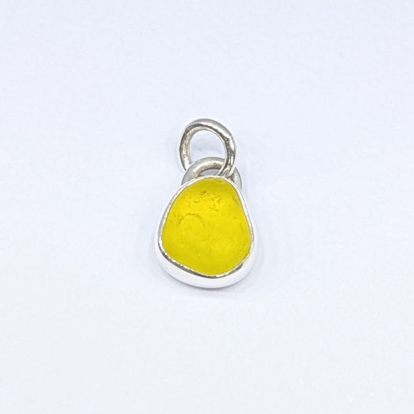 Front view of Rare yellow sea glass silver pendant with white background