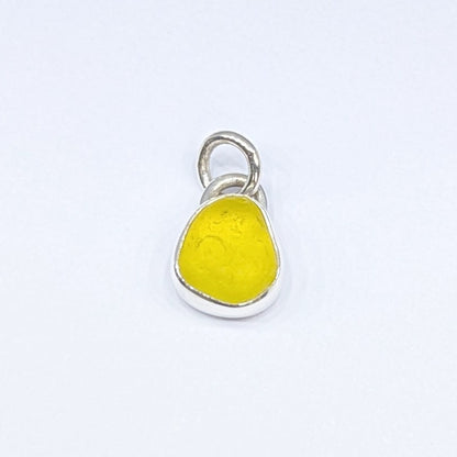 Front view of Rare yellow sea glass silver pendant with white background
