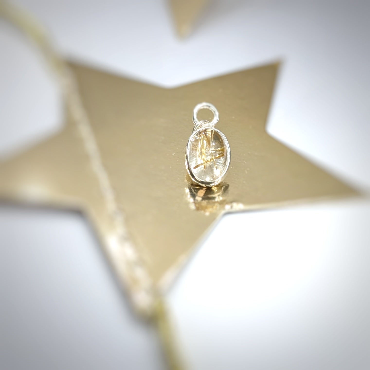 Golden Sparkle Quartz pendant in sterling silver sitting on golden star
