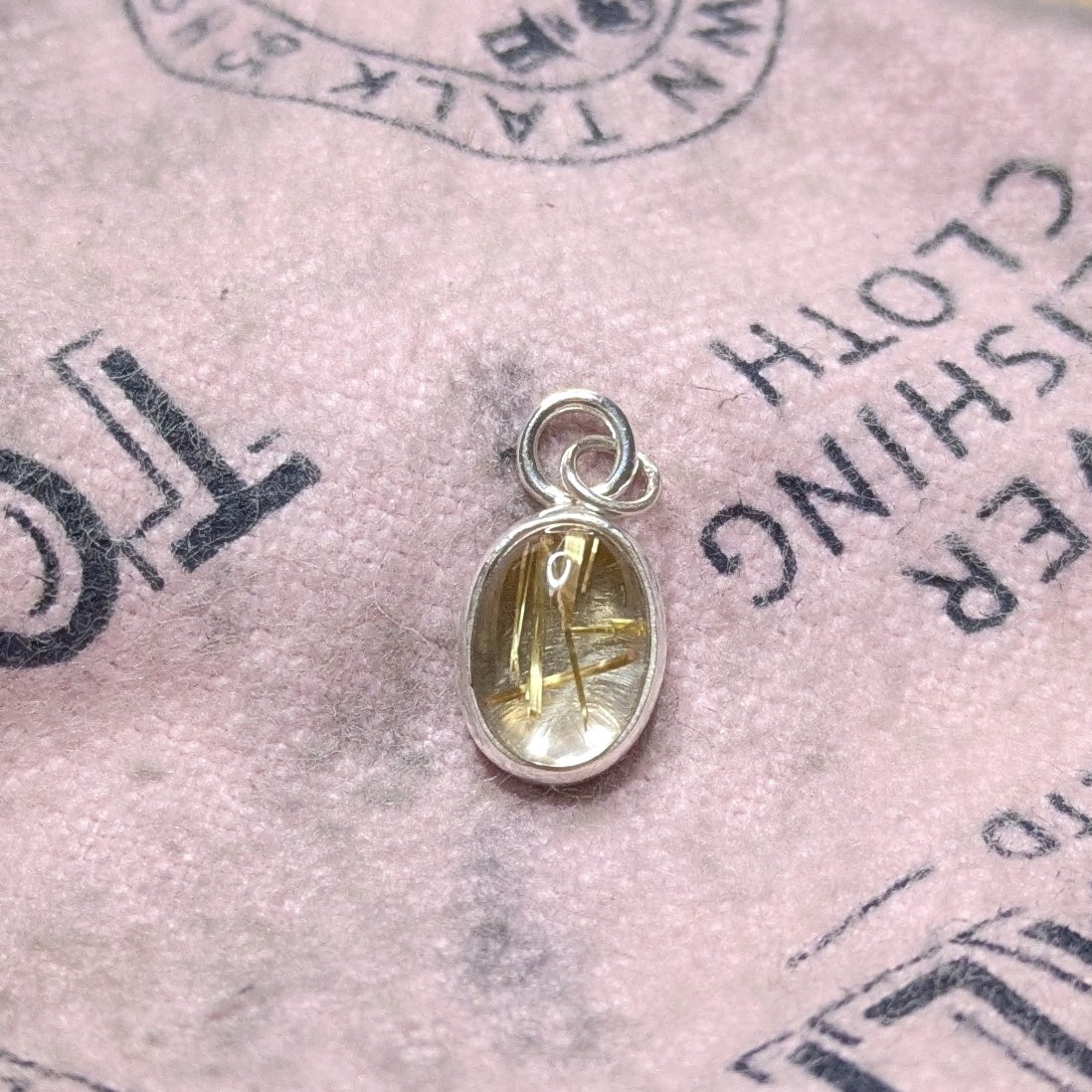 Golden Sparkle Quartz pendant in sterling silver on pink polishing cloth