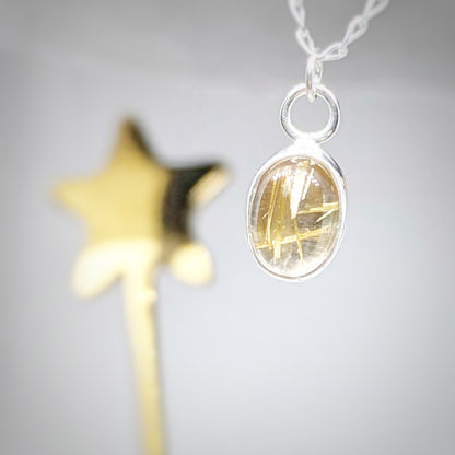 Golden Sparkle Quartz pendant in sterling silver next to golden star