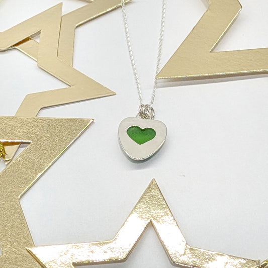 Green Sea Glass silver pendant with heart shape cut out, with silver chain and festive gold star decorations.