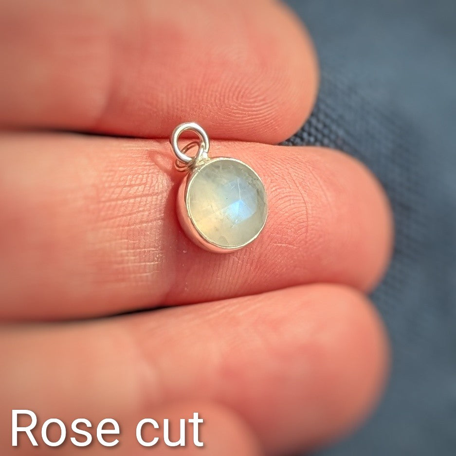 Close up of Rose cut Snowball Moonstone pendant set in sterling silver in hand
