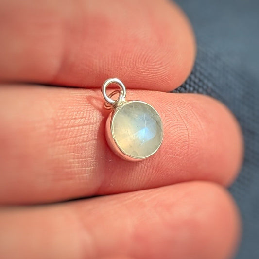 Close up of Rose cut Snowball Moonstone pendant set in sterling silver in hand