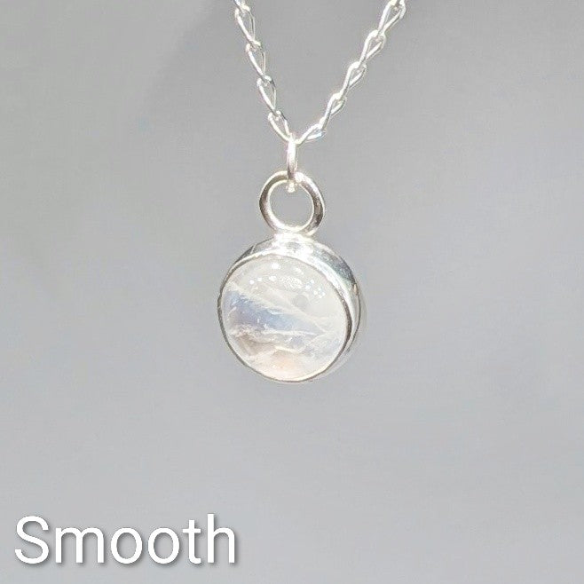 Close up of Smooth cut Snowball Moonstone pendant set in sterling silver on silver chain