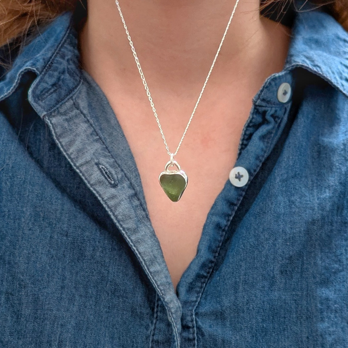 Model wearing St Ives Green sea glass silver pendant with heart cut out