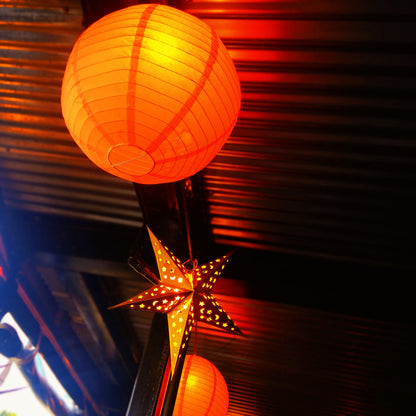 Bright orange ceiling paper ball and star lanterns.