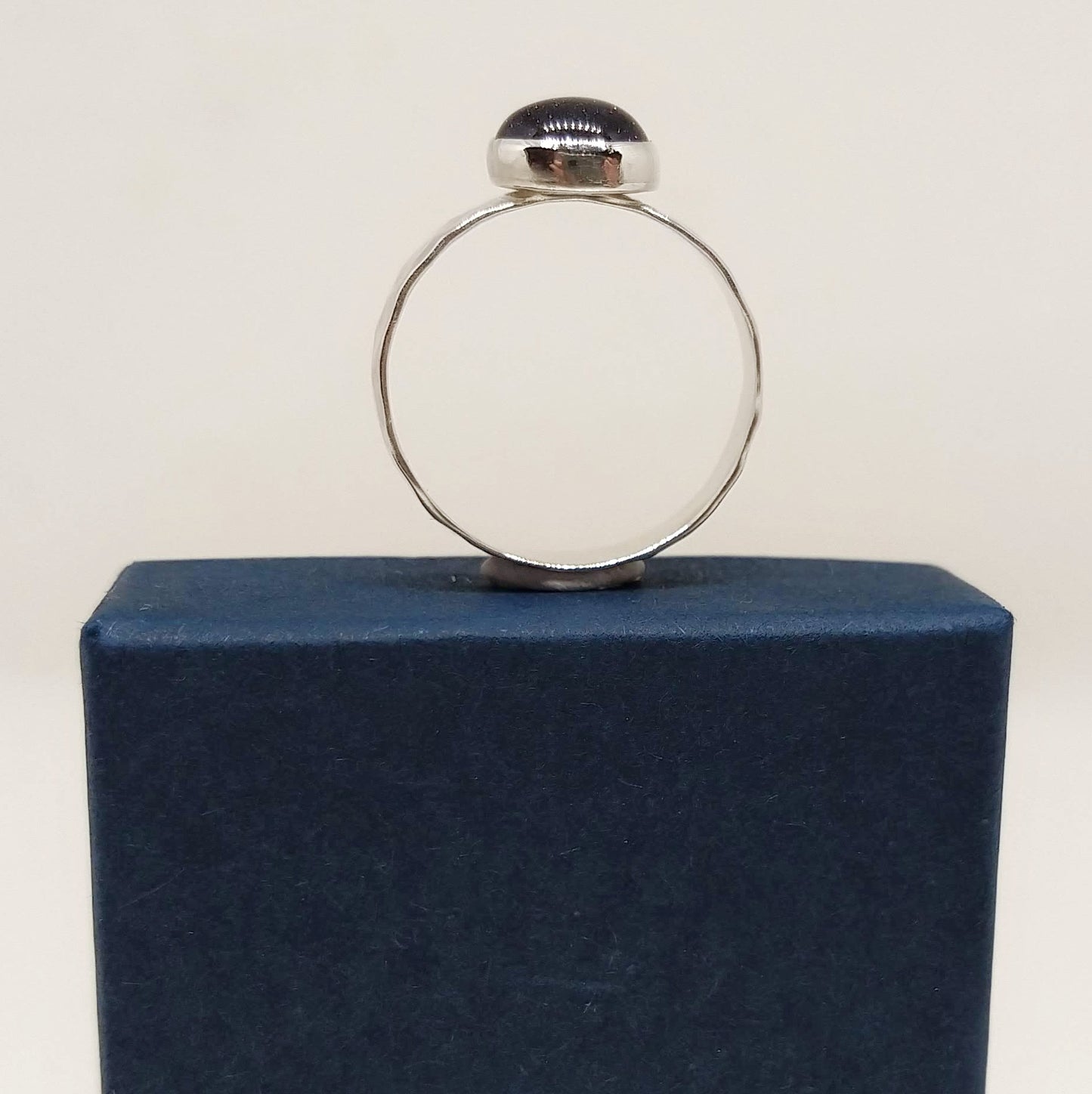 Side view of Blue Goldstone Silver Hammered Ring sitting on blue gift box