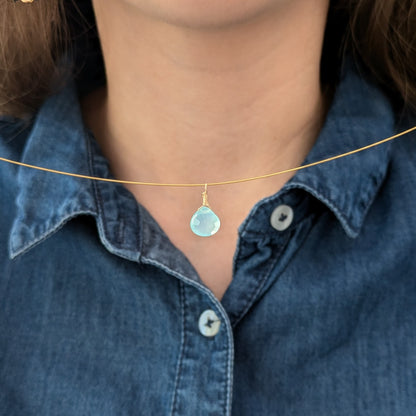 Blue and gold drop pendant.  Model holding up Dreamy Blue Chalcedony Drop Pendant