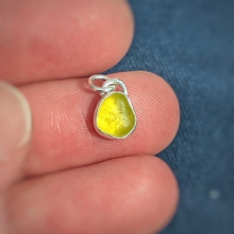 Rare yellow sea glass silver pendant in hand