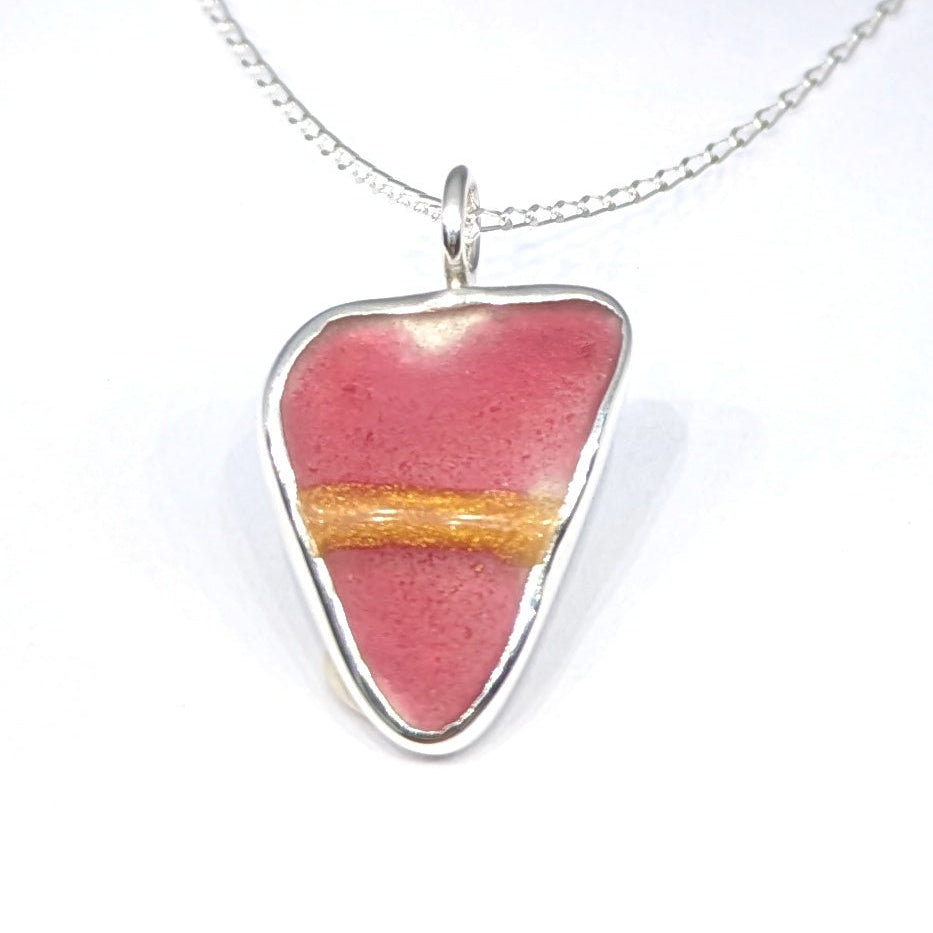 Close up of Red Sea Glass Silver Pendant on white background