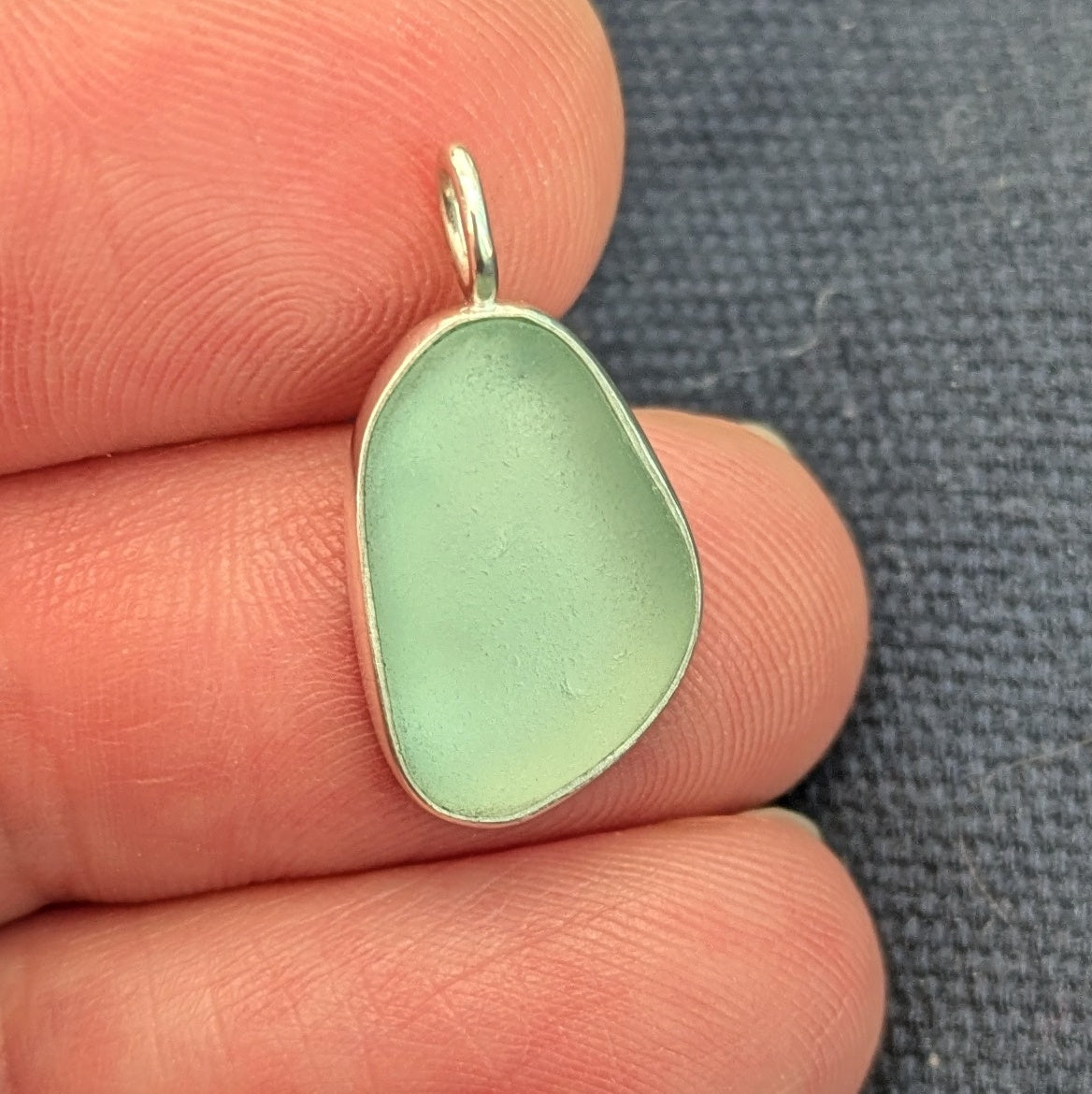 hand holding Seafoam sea glass silver pendant