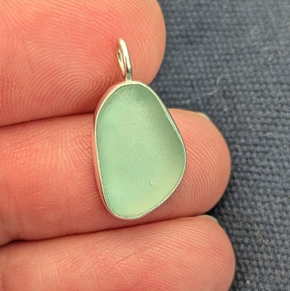 hand holding Seafoam sea glass silver pendant