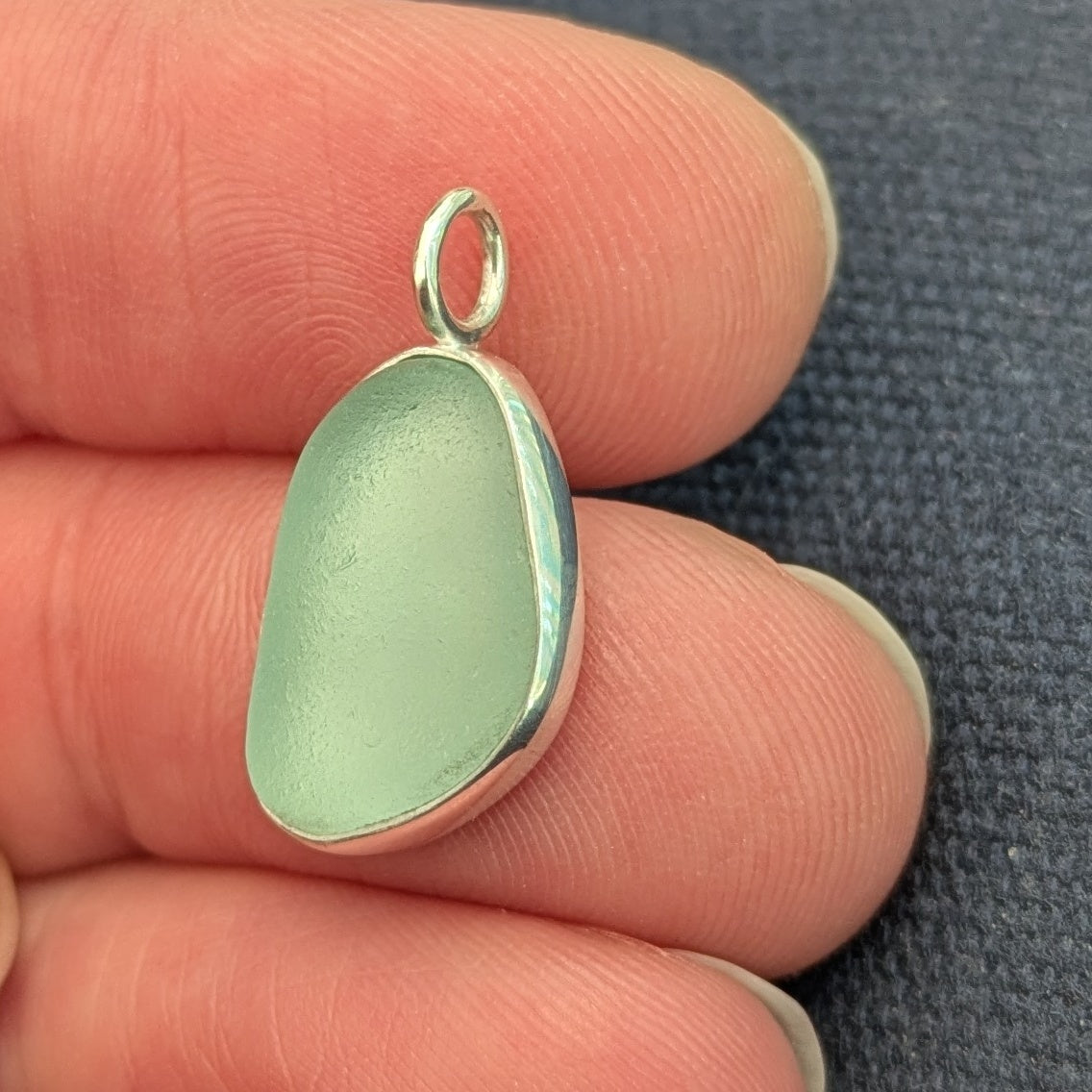 Hand holding Seafoam sea glass silver pendant