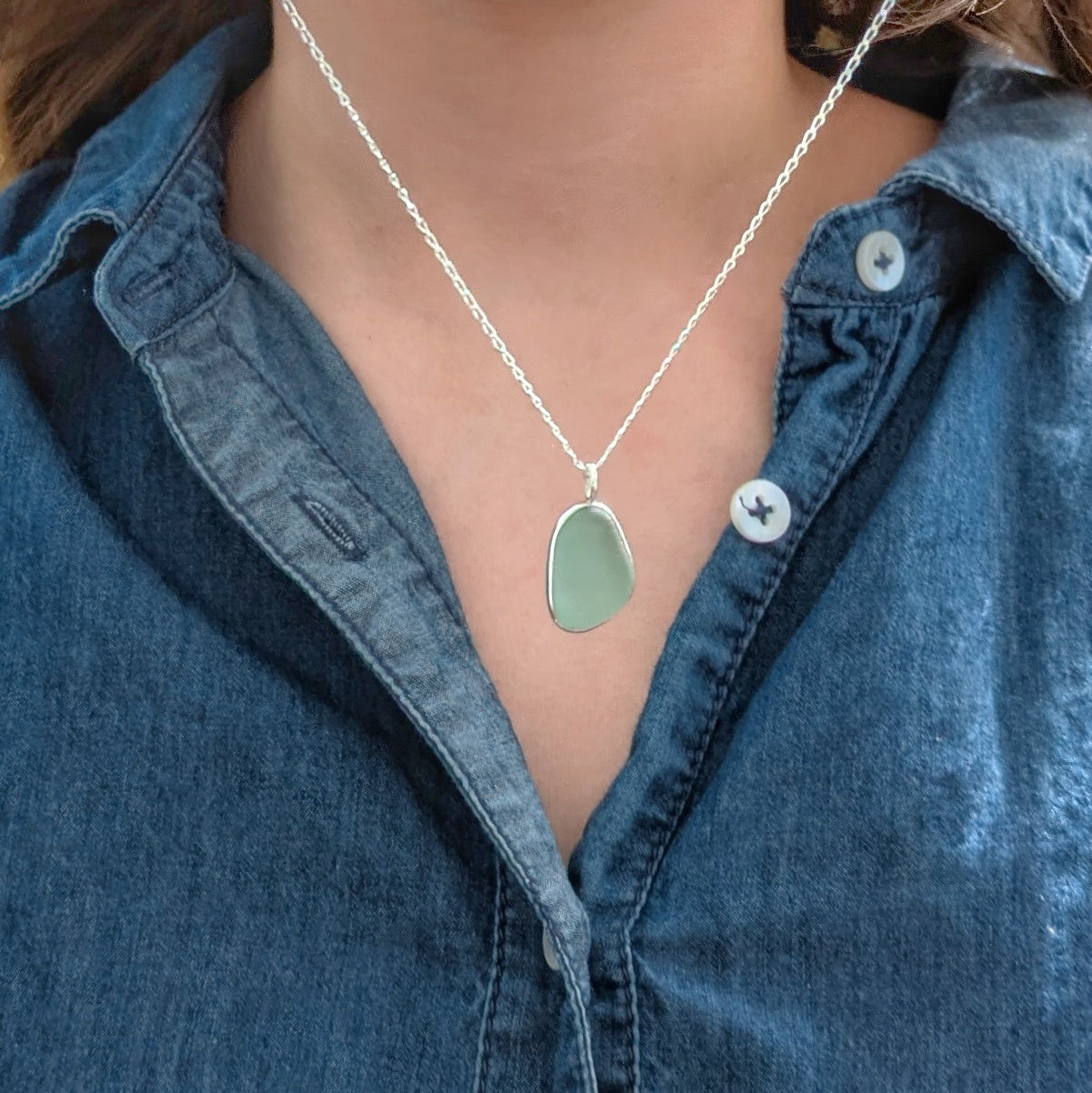 Seafoam sea glass silver pendant on model