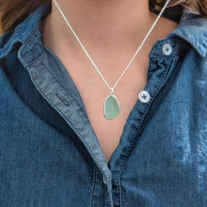 Seafoam sea glass silver pendant on model