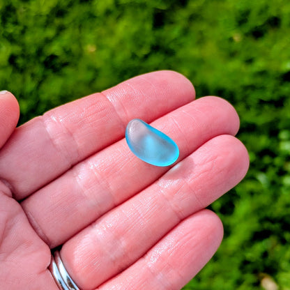 Hand holding a rare turquoise sea glass 'bean'