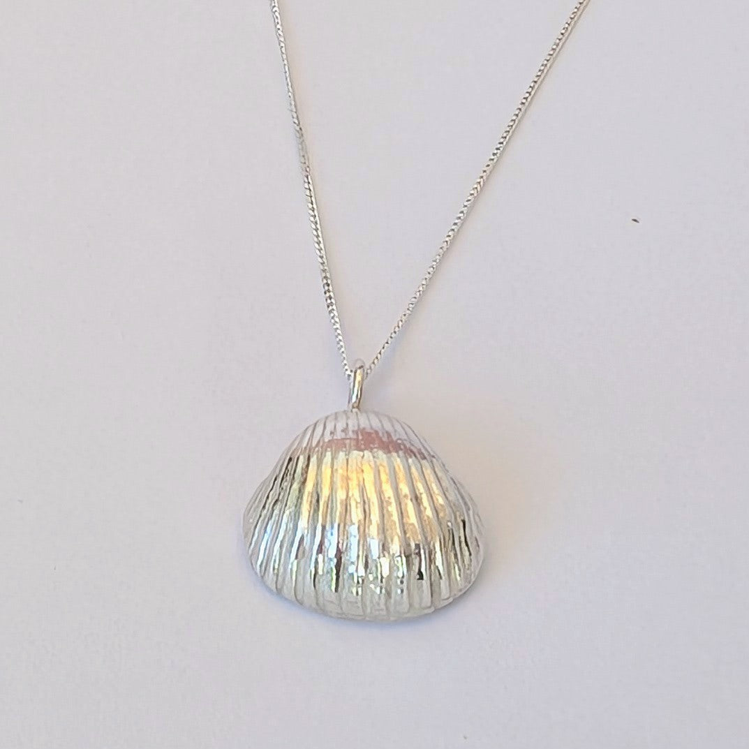 Pure Silver sea shell pendant cast from a real sea shell on white background