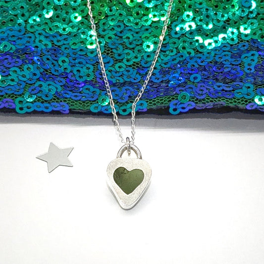 St Ives Green sea glass silver pendant with heart shaped cut out on silver chain, with festive background.