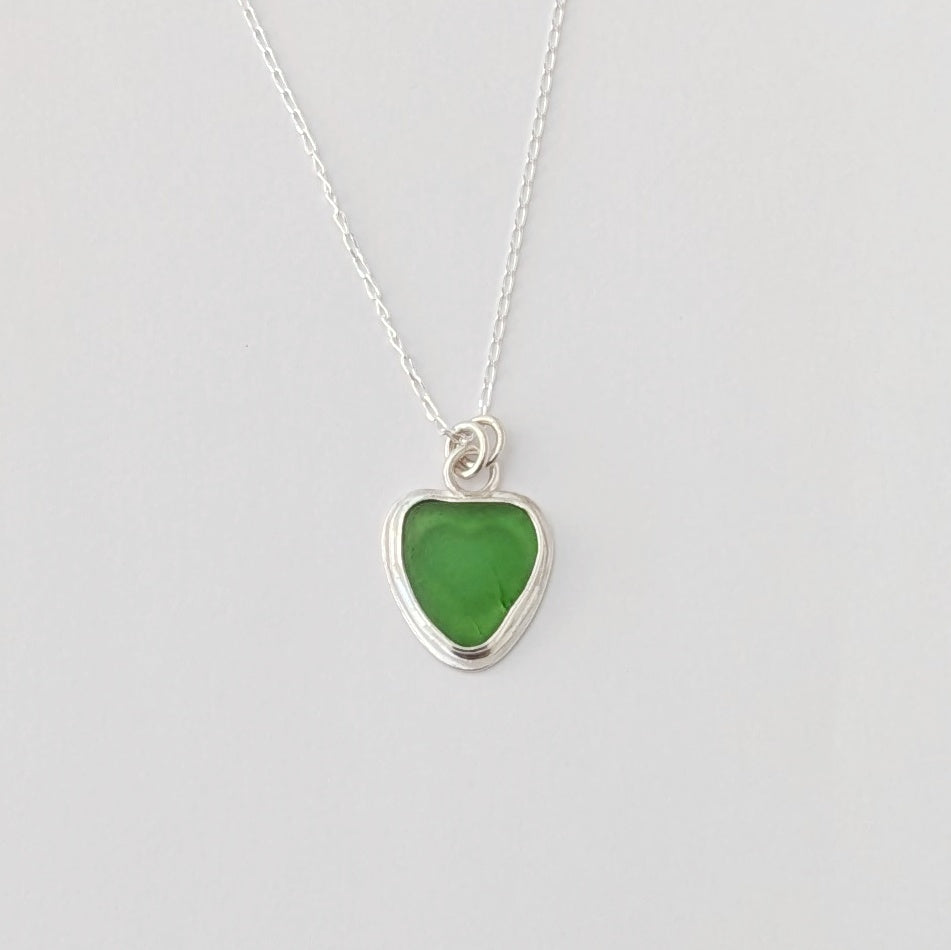 Front view of Green Sea Glass silver pendant with heart shape cut out, with silver chain 