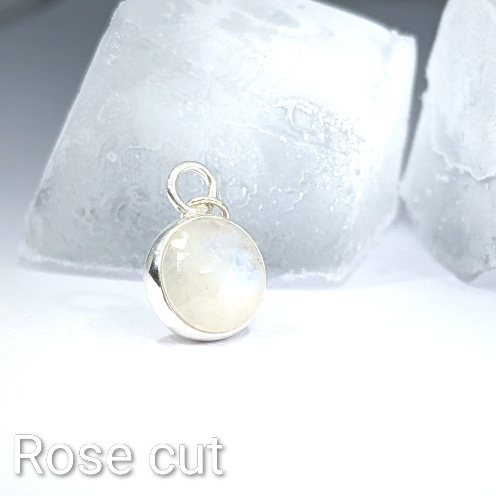 Close up of the rose cut Snowball Moonstone pendant set in sterling silver with an ice cube background