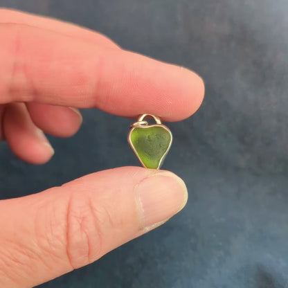 Hand holding finished heart  shaped green sea glass silver pendant