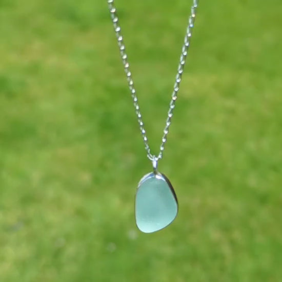 video of Seafoam sea glass silver pendant outside