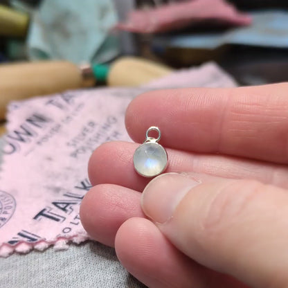 video of rose cut Snowball Moonstone pendant set in sterling silver in hand at work bench