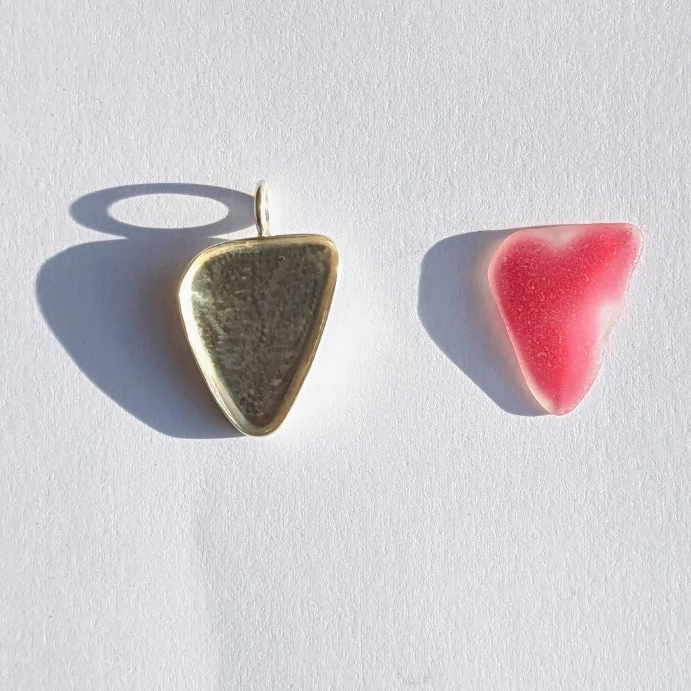 Red Sea glass heart next to silver bezel with background